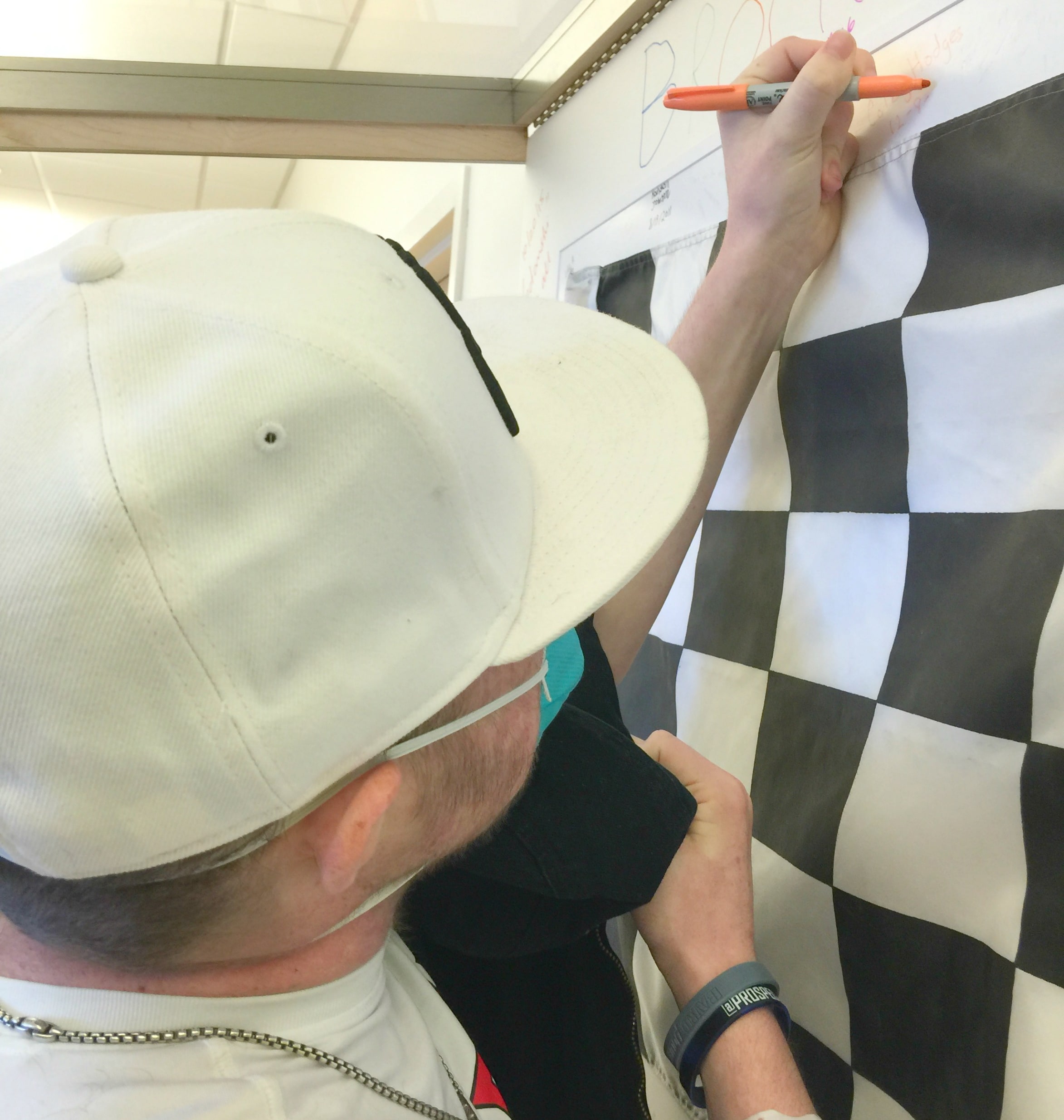 man signing checkered race flag