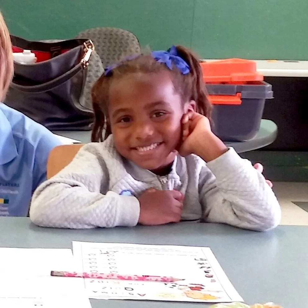 An african american school-aged child in the classroom with a wolfson children's health educator