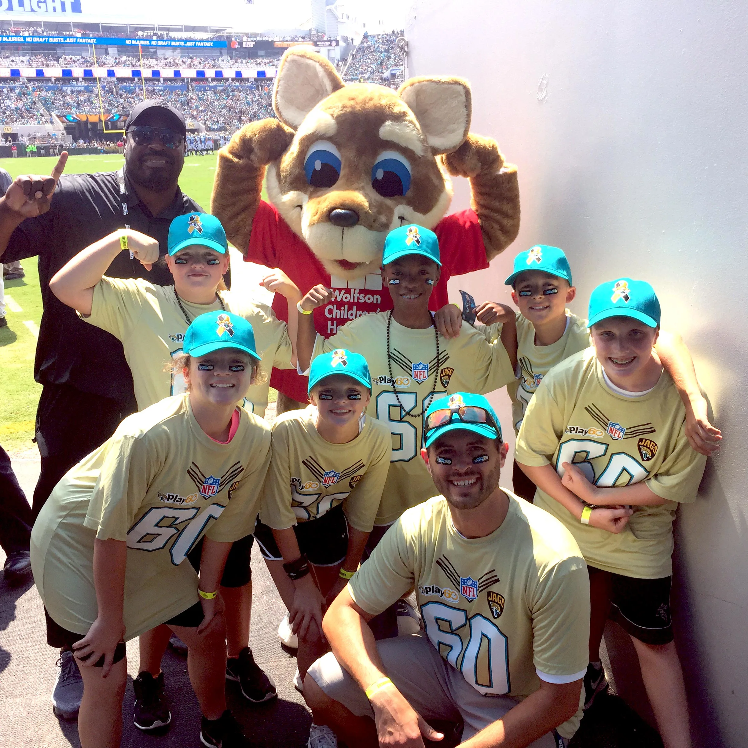 a youth group with the Wolfson mascot at a football game