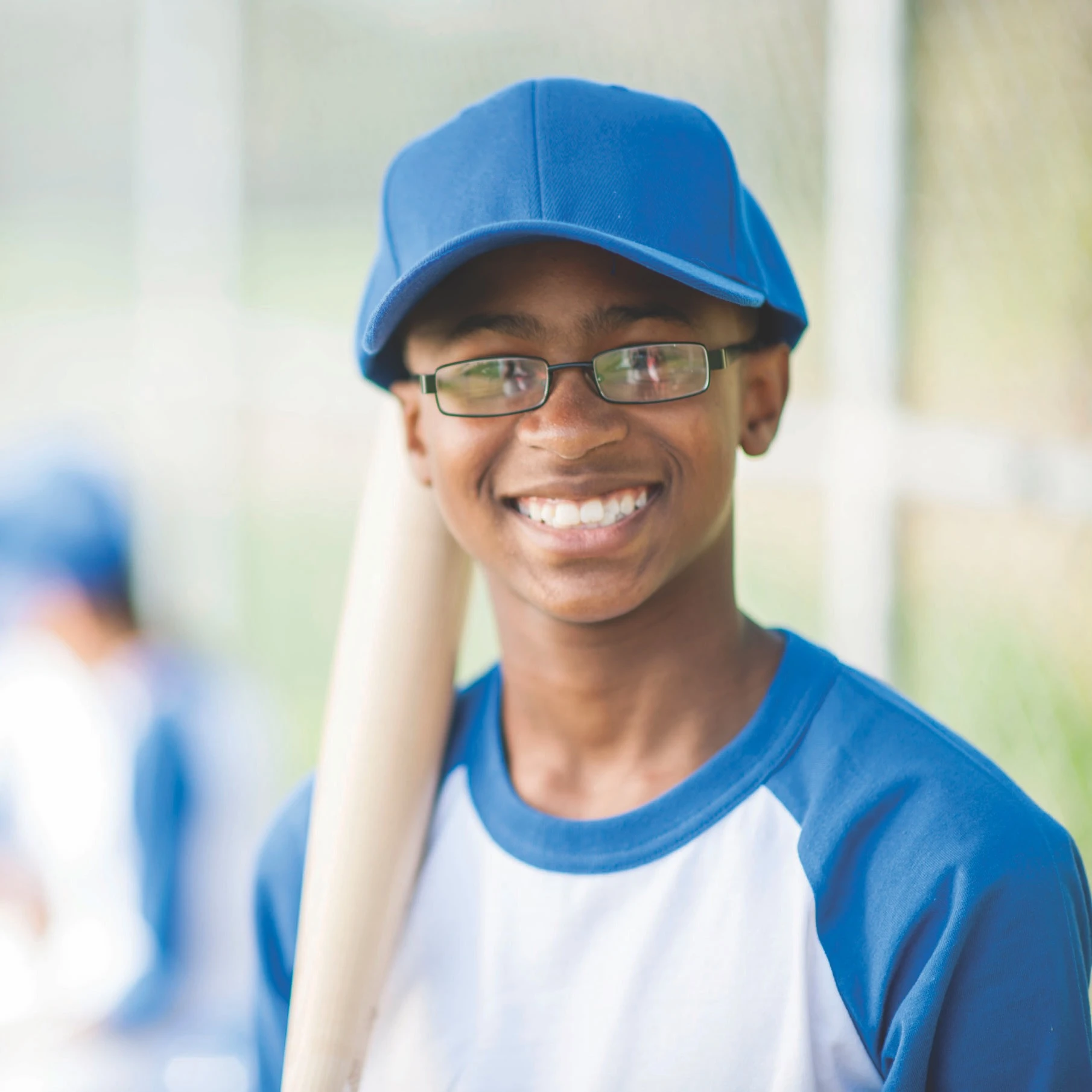 a teen in baseball gear holding a bat