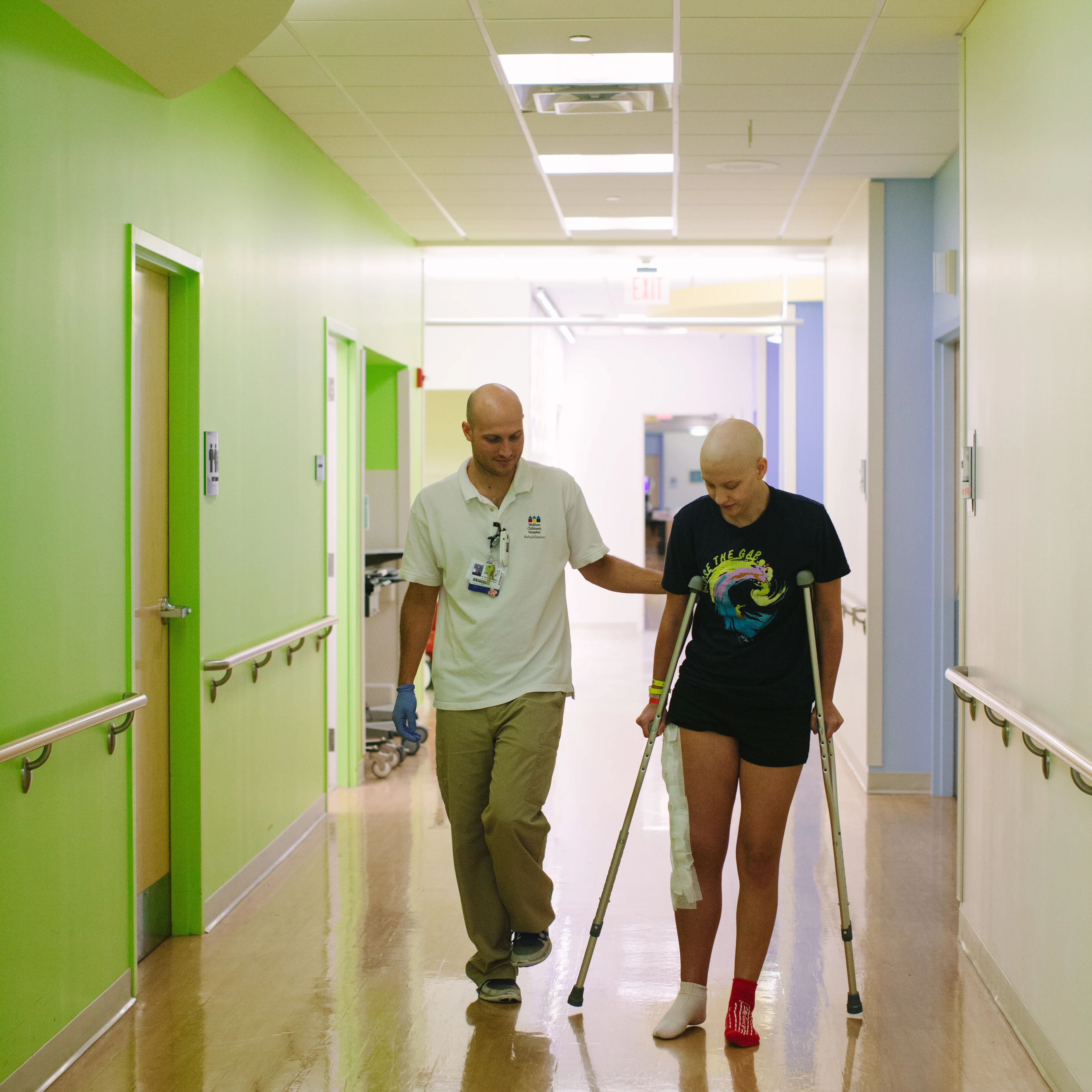 Physical therapist working with a pediatric patient on crutches