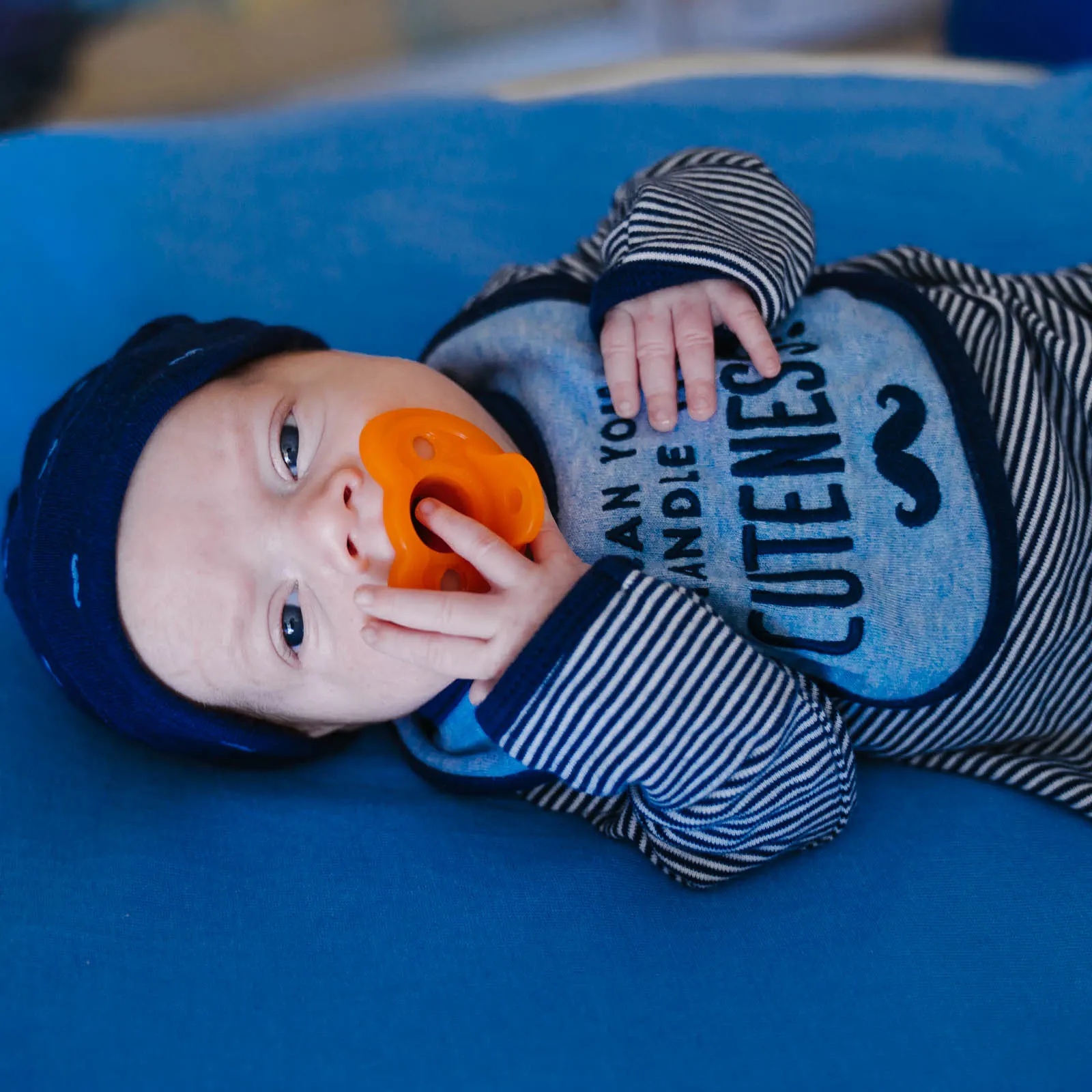 Wolfson Children's infant heart patient looking at camera with pacifier in his mouth