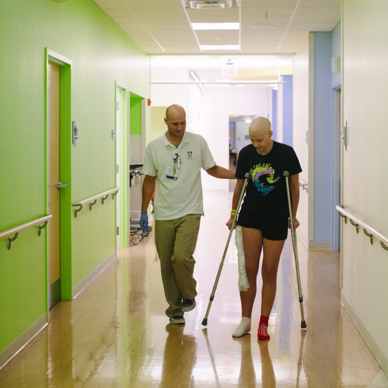 Physical therapist working with a pediatric patient on crutches
