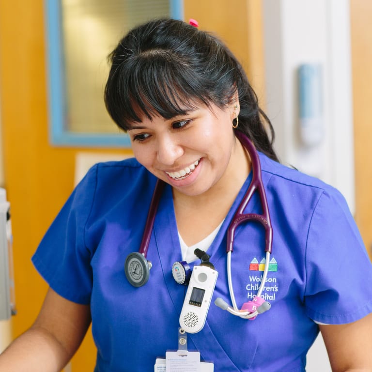 smiling medical provider in Wolfson scrubs wearing a stethoscope