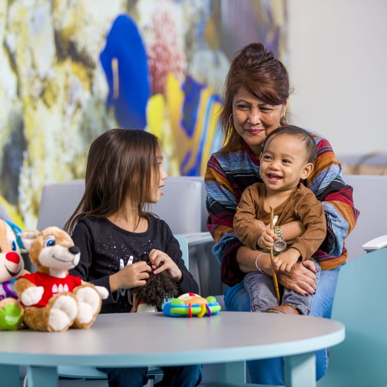 mom sitting with her two children in the waiting room of the Emergency Room at Wolfson Children's Hospital