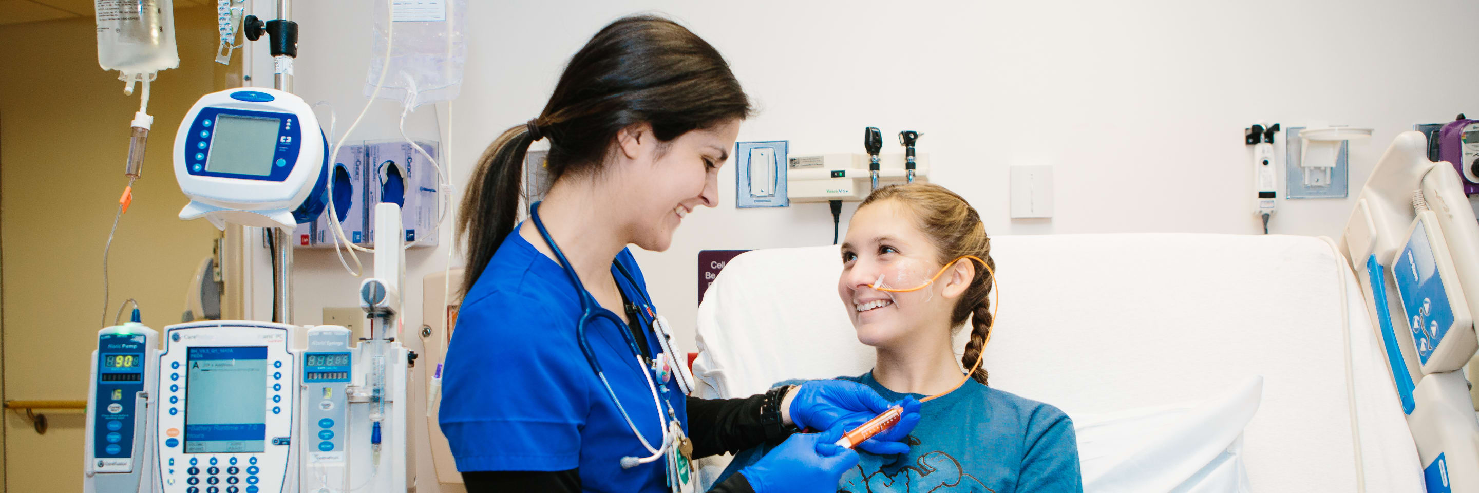 Nurse helping teenager at bedside
