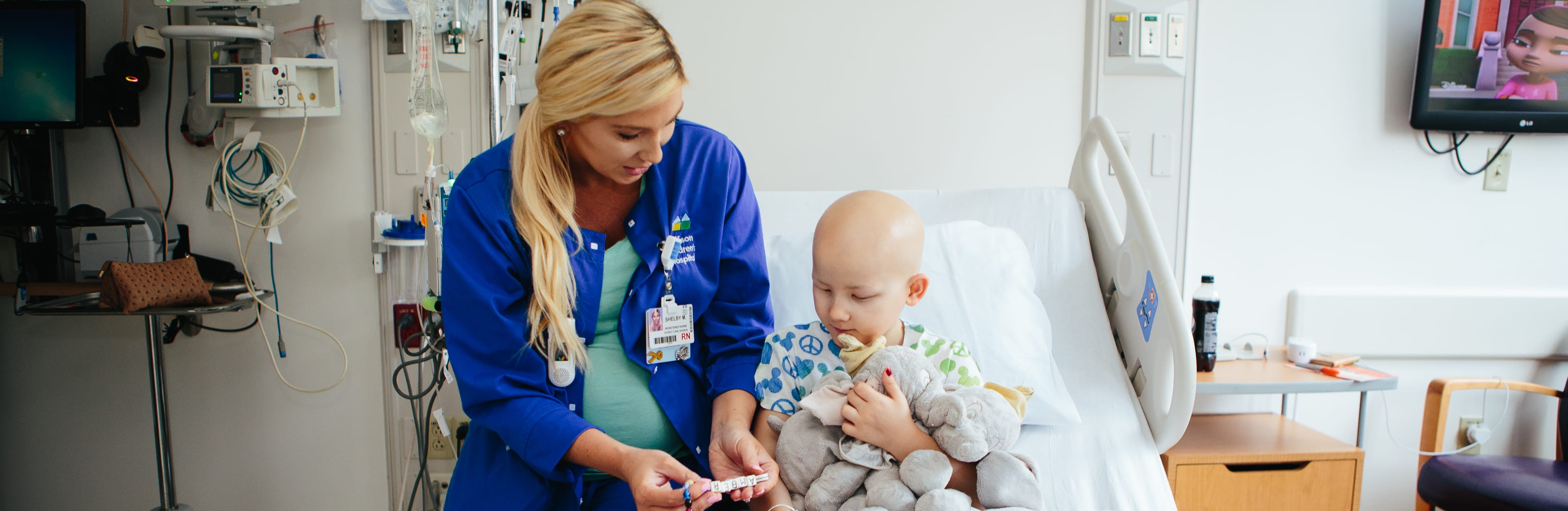 Nurse sitting with child cancer patient