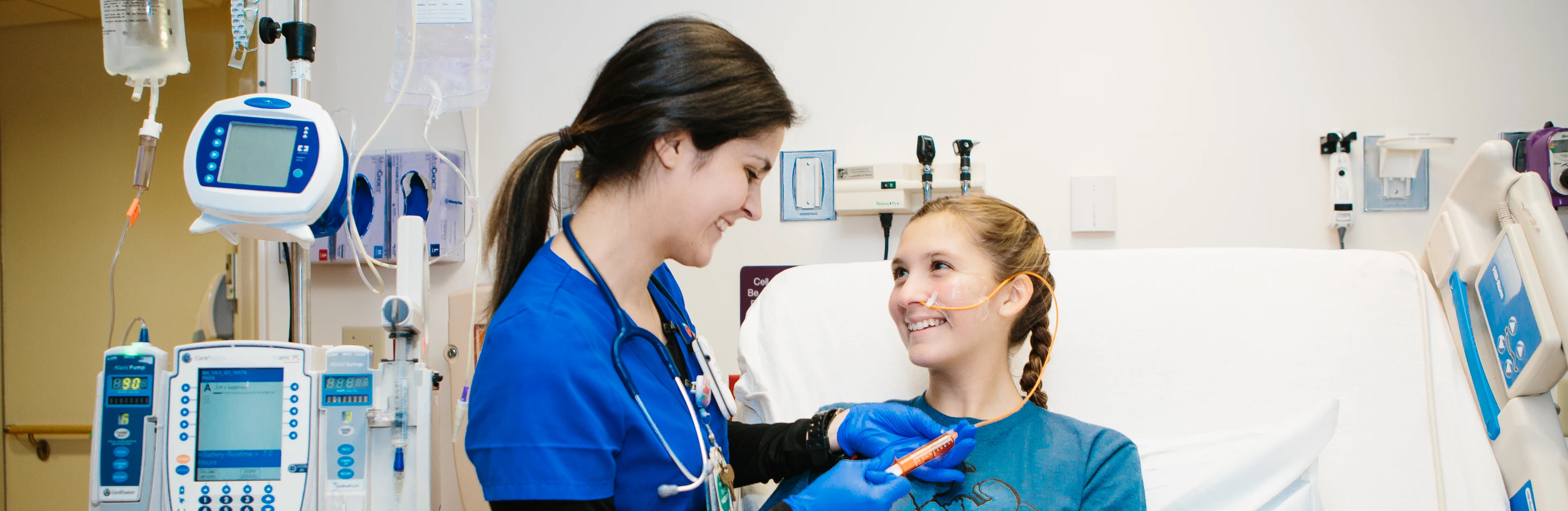 Nurse helping teenager at bedside