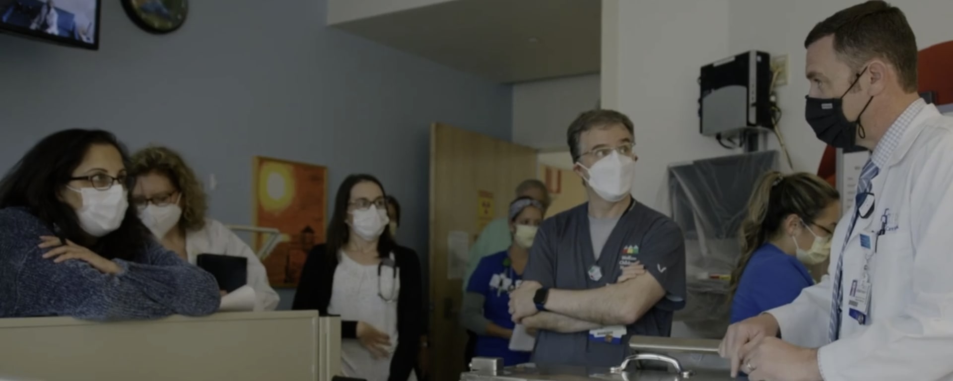 a group of providers huddle in the MIBG patient room to discuss treatments.