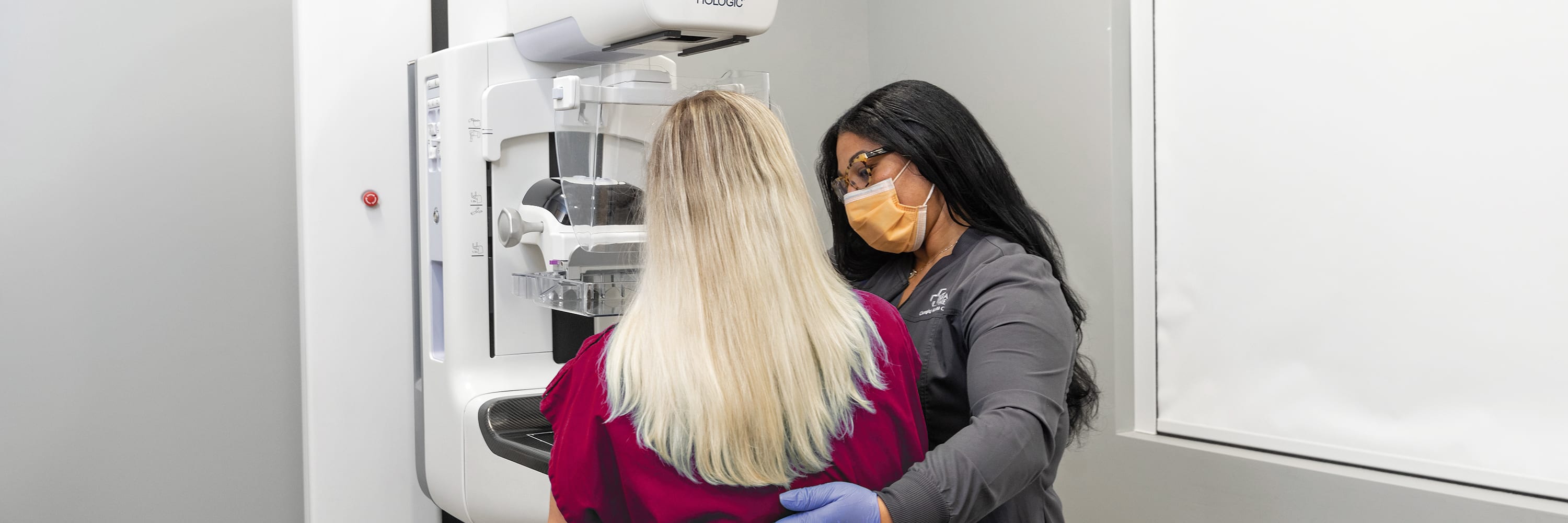 a woman is getting a mammogram as the imaging specialists helps