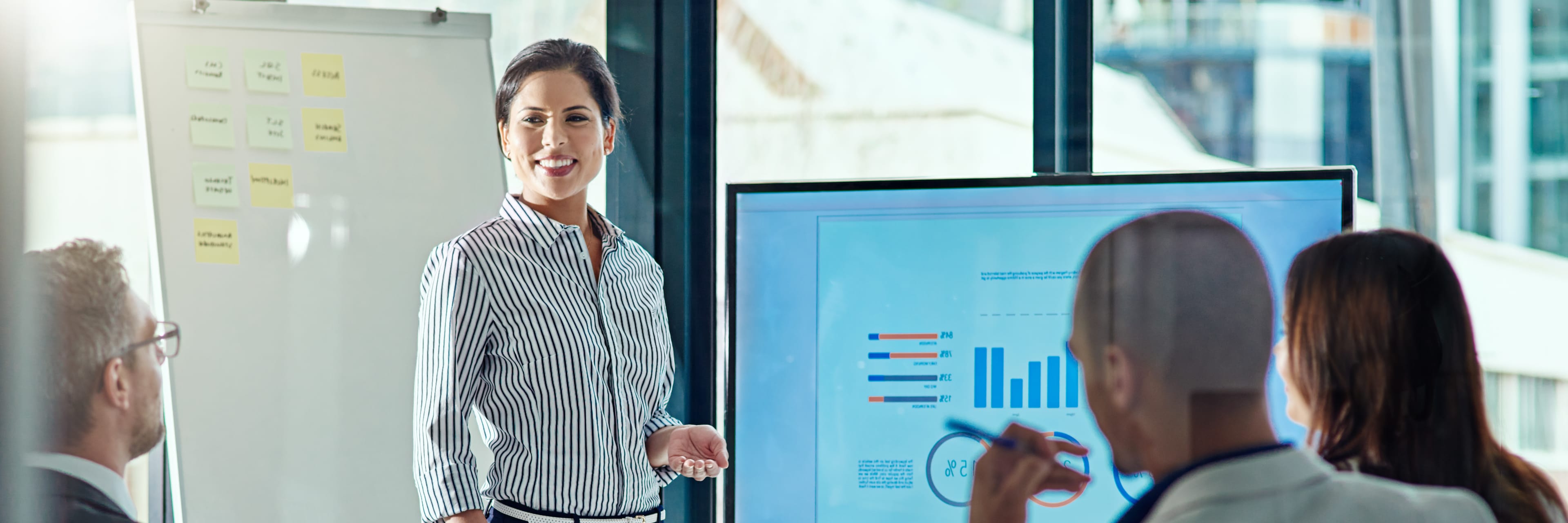 women giving a presentation to coworkers around a table