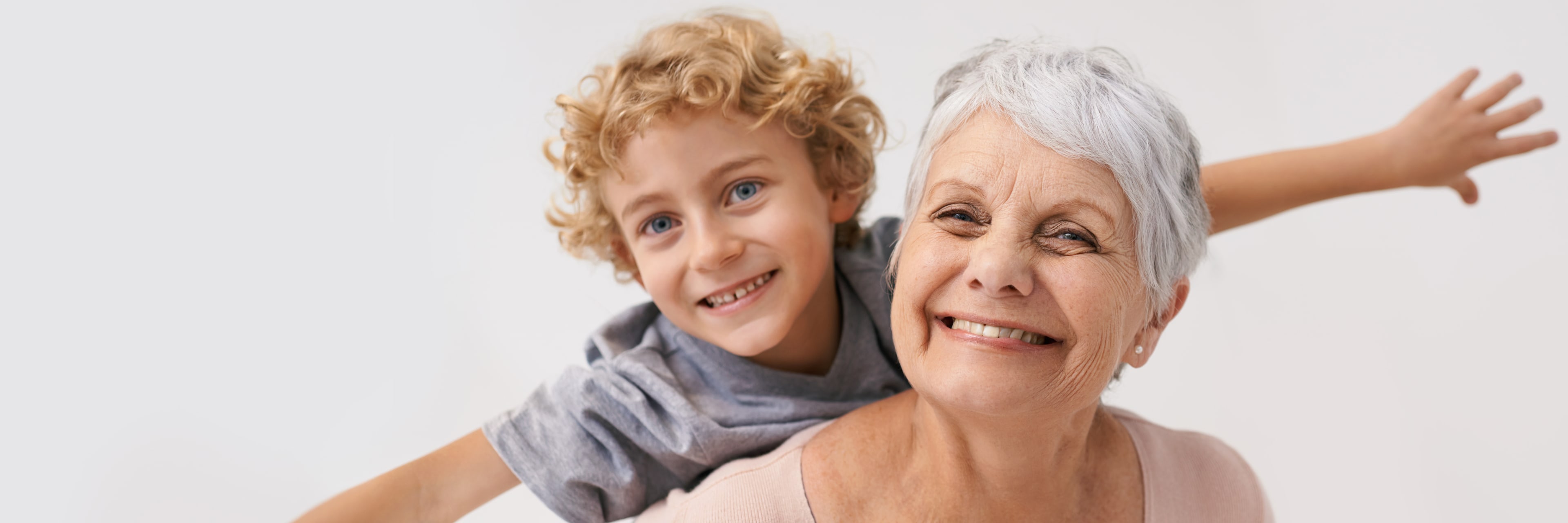 smiling woman giving her grandson a piggyback ride