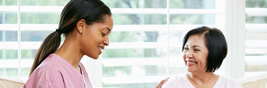 A smiling woman talks with a healthy living coach