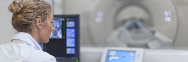 woman in front of an MRI machine