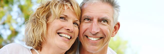 smiling couple sitting outside staring into the distance