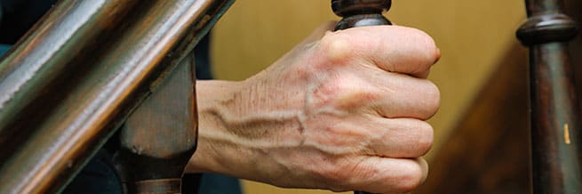 Hand grasping the banister of a staircase