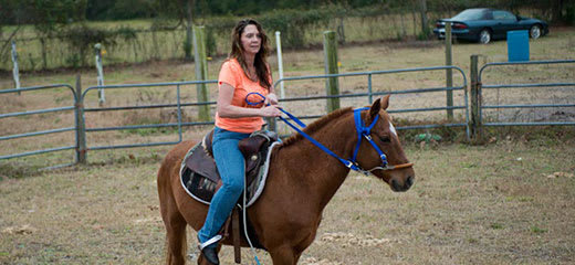 Woman riding a horse at a ranch