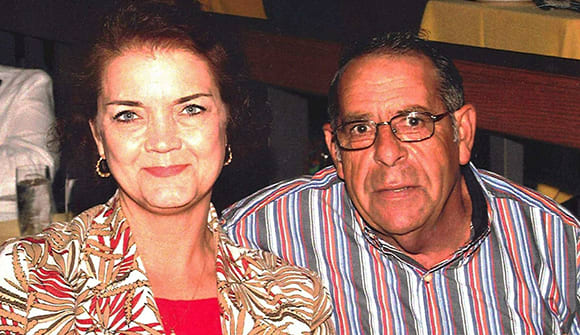 photo of wife and husband, Susan and Jim Taylor, sitting together in a restaurant, smiling