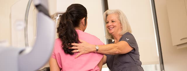 medical worker assisting woman getting a mammogram