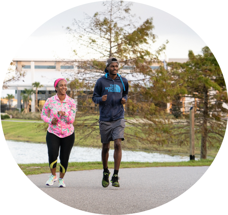 a man and woman jogging on the path at Baptist Clay Medical Campus.