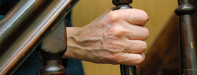 Hand grasping the banister of a staircase