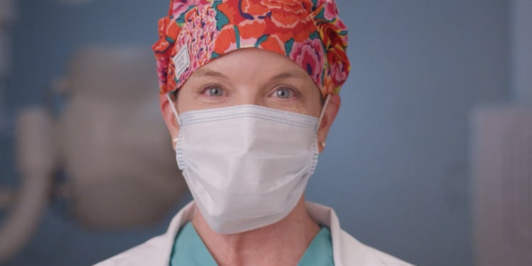 Upclose image of Female Health care Provider's face wearing a surgical mask.