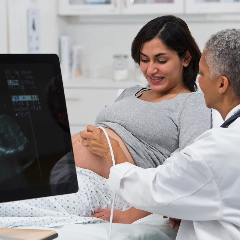 doctor performing an ultrasound on a pregnant woman