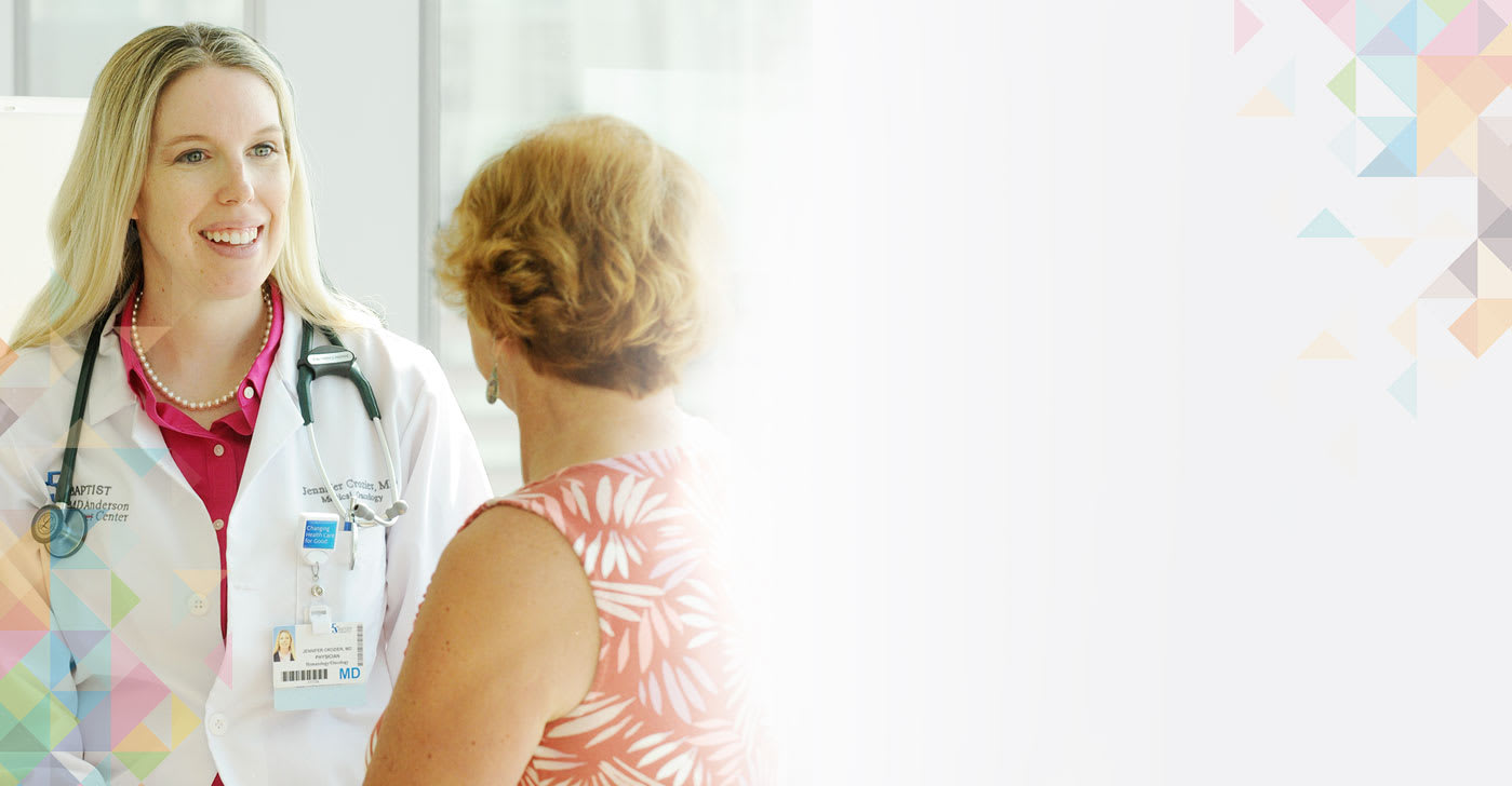 Dr. Jennifer Crozier, a hematologist oncologist, smiles with a female patient.