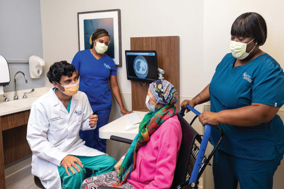 interventional pulmonologist and thoracic oncology program nurse talk with patient about her treatment plan