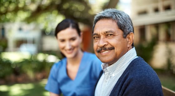 Portrait of a senior man spending time in the garden with a young nurse