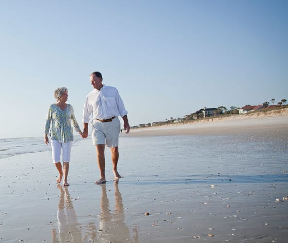 A senior couple walk along Jacksonville beach.