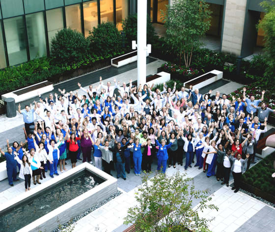 An aerial photo of a big, group of care team professionals in the Baptist MD Anderson courtyard.