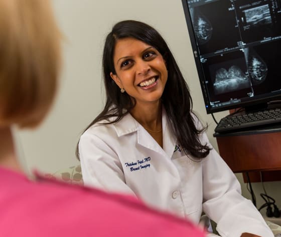 A physician smiles kindly at her patient.