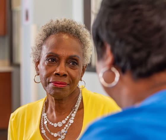 A female breast cancer patient looks toward her nurse navigator.