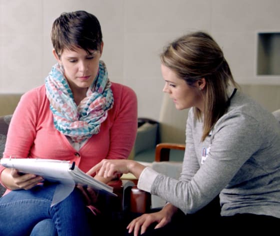 A female Baptist MD Anderson healthcare professional goes through the patient binder with a female patient.