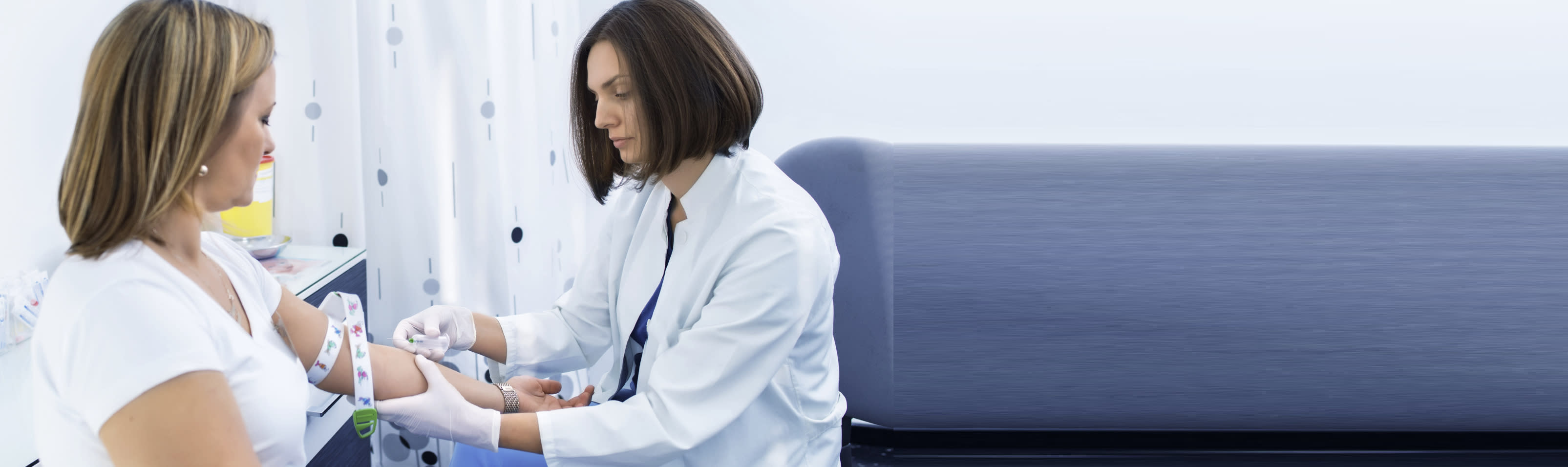 female health care worker drawing blood from a female patient.