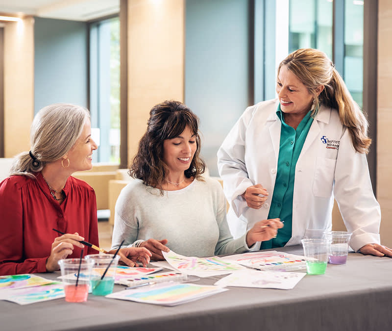 A group of patients and healthcare professional paint with watercolors.