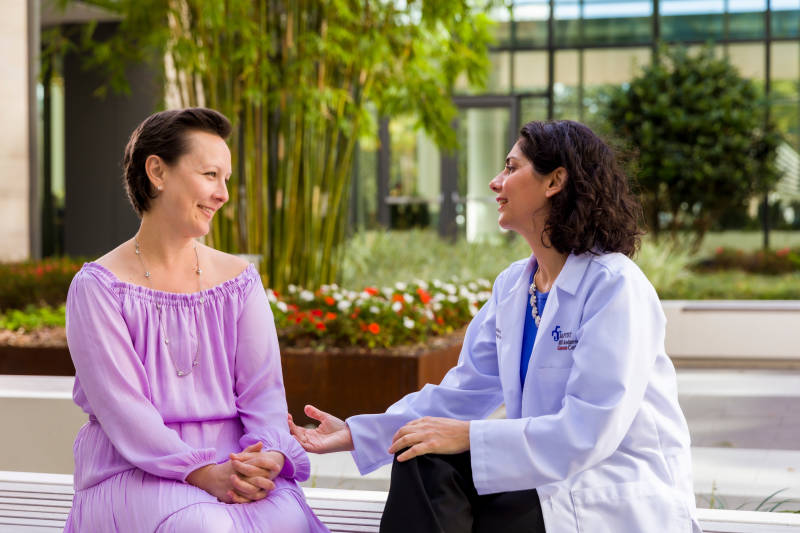 A female patient rings the survivorship bell, her husband by her side, to celebrate the end of treatment.