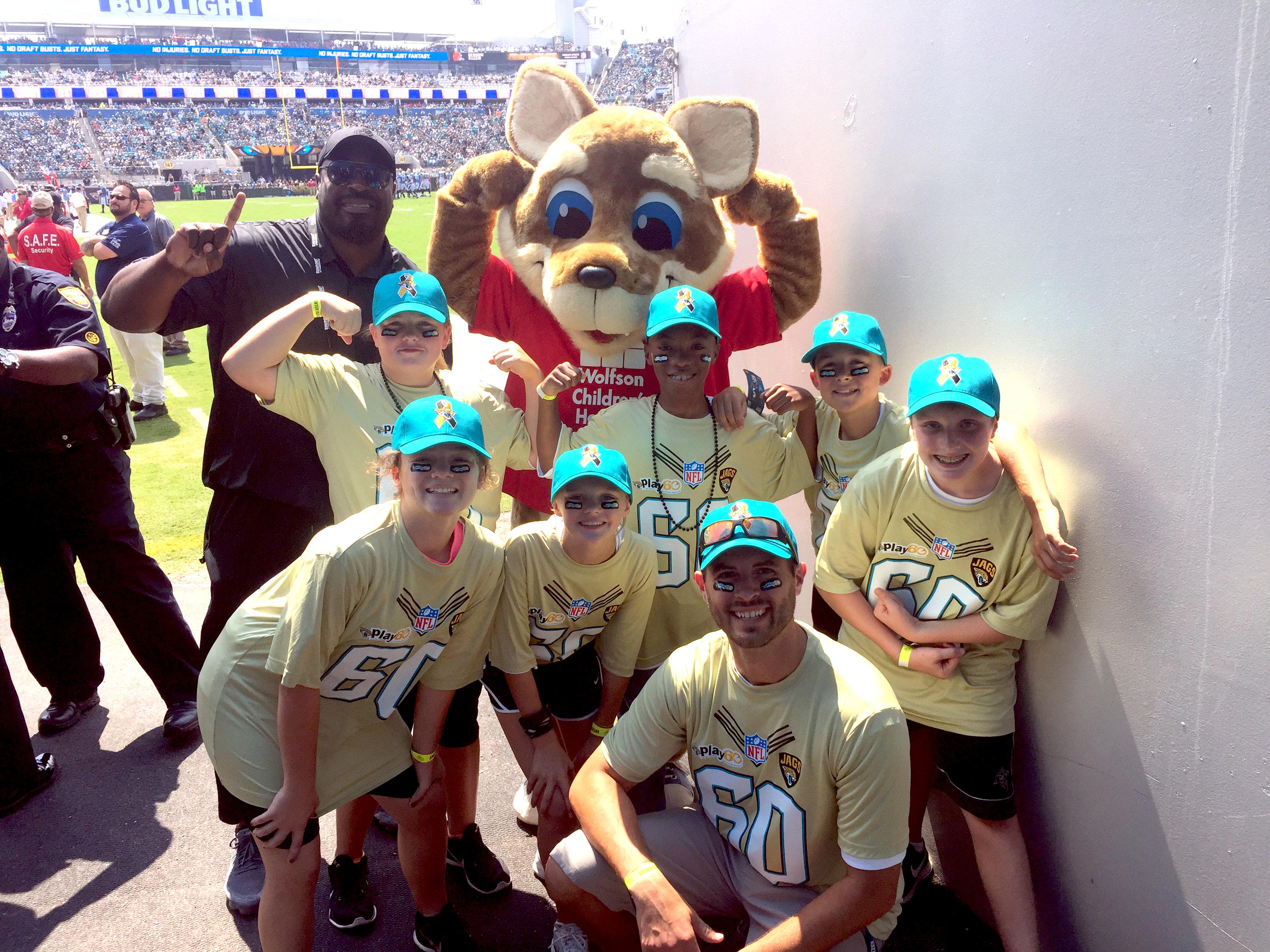 a youth group with the Wolfson mascot at a football game