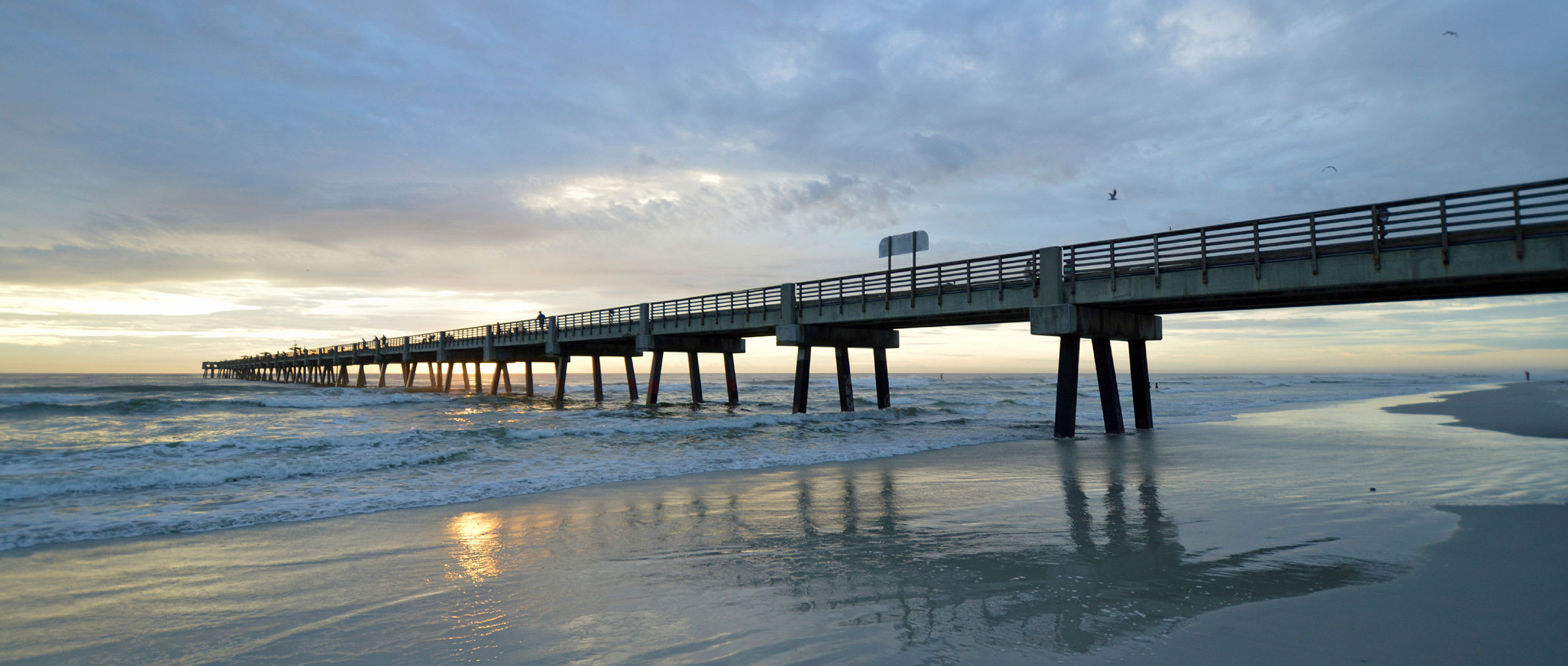 Pier extending in to the ocean from the beach