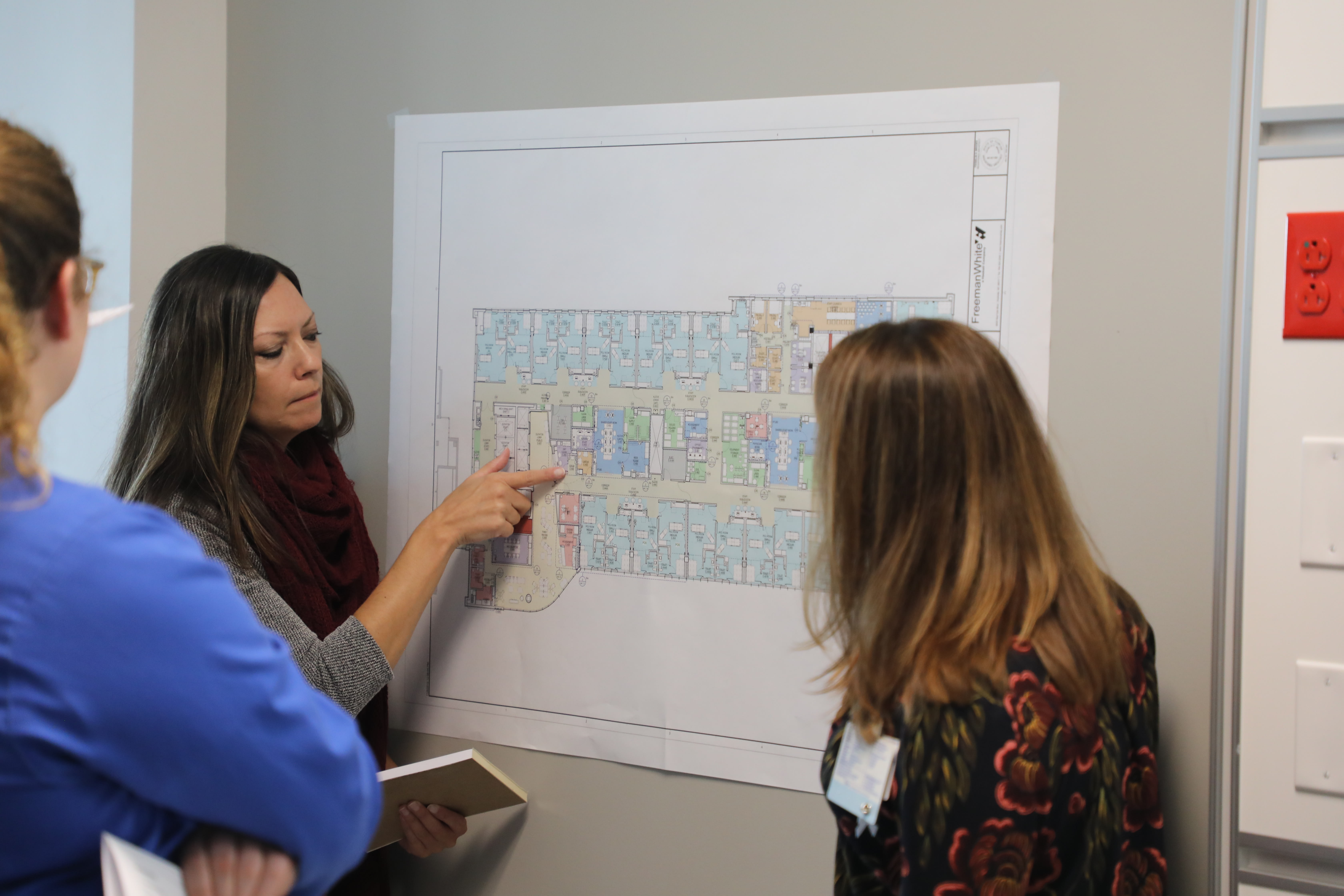 Woman pointing to a map of the Critical Care tower