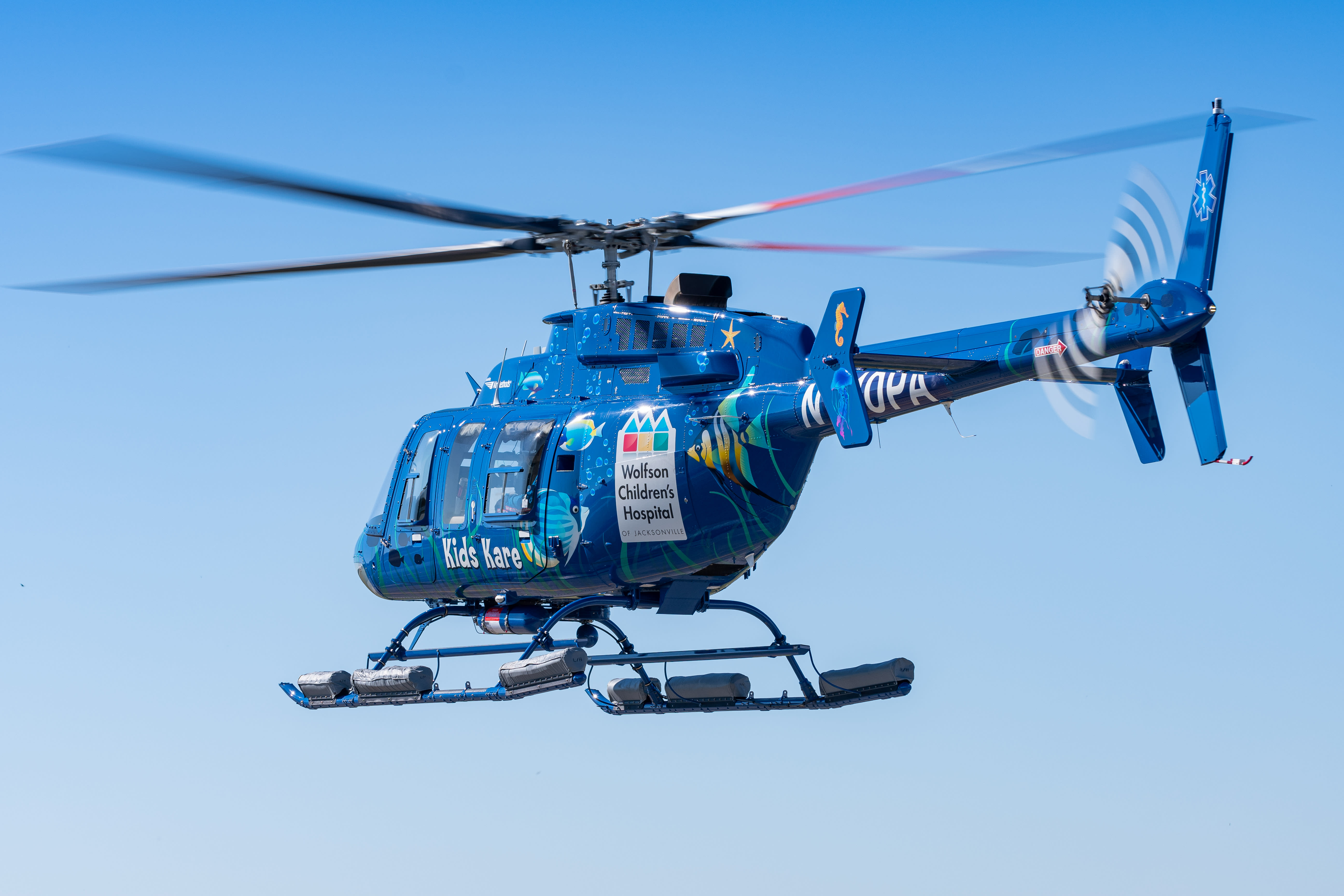 Kids Kare helicopter flying in a blue sky