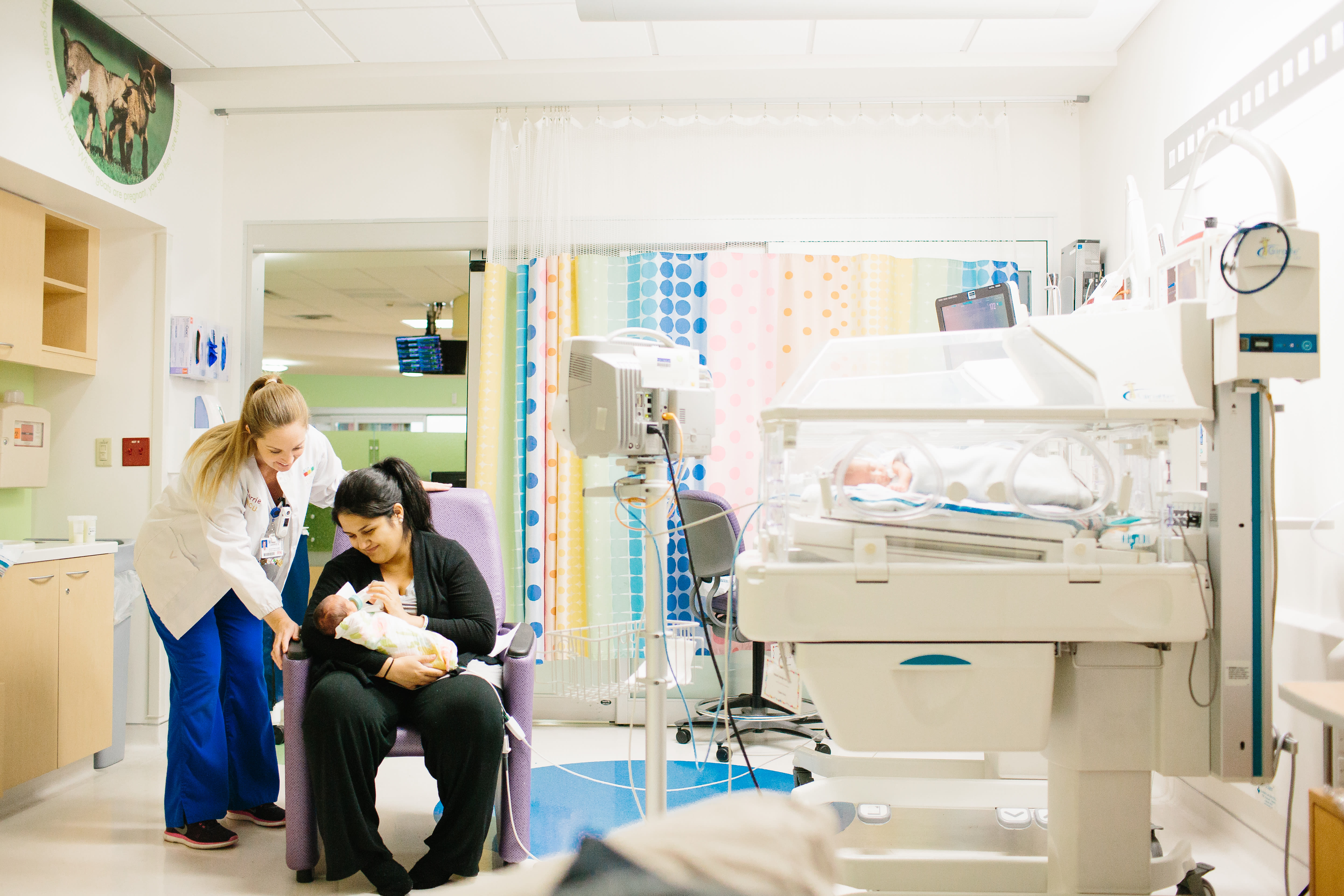 mother and Wolfson Children's medical professional looking at newborn in mother's arms