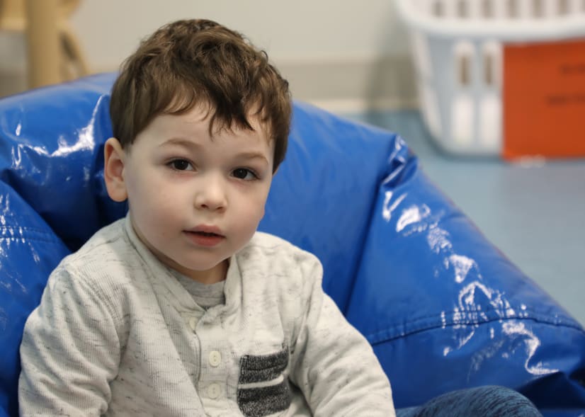 photo of a male toddler sitting on a blue bean bag chair