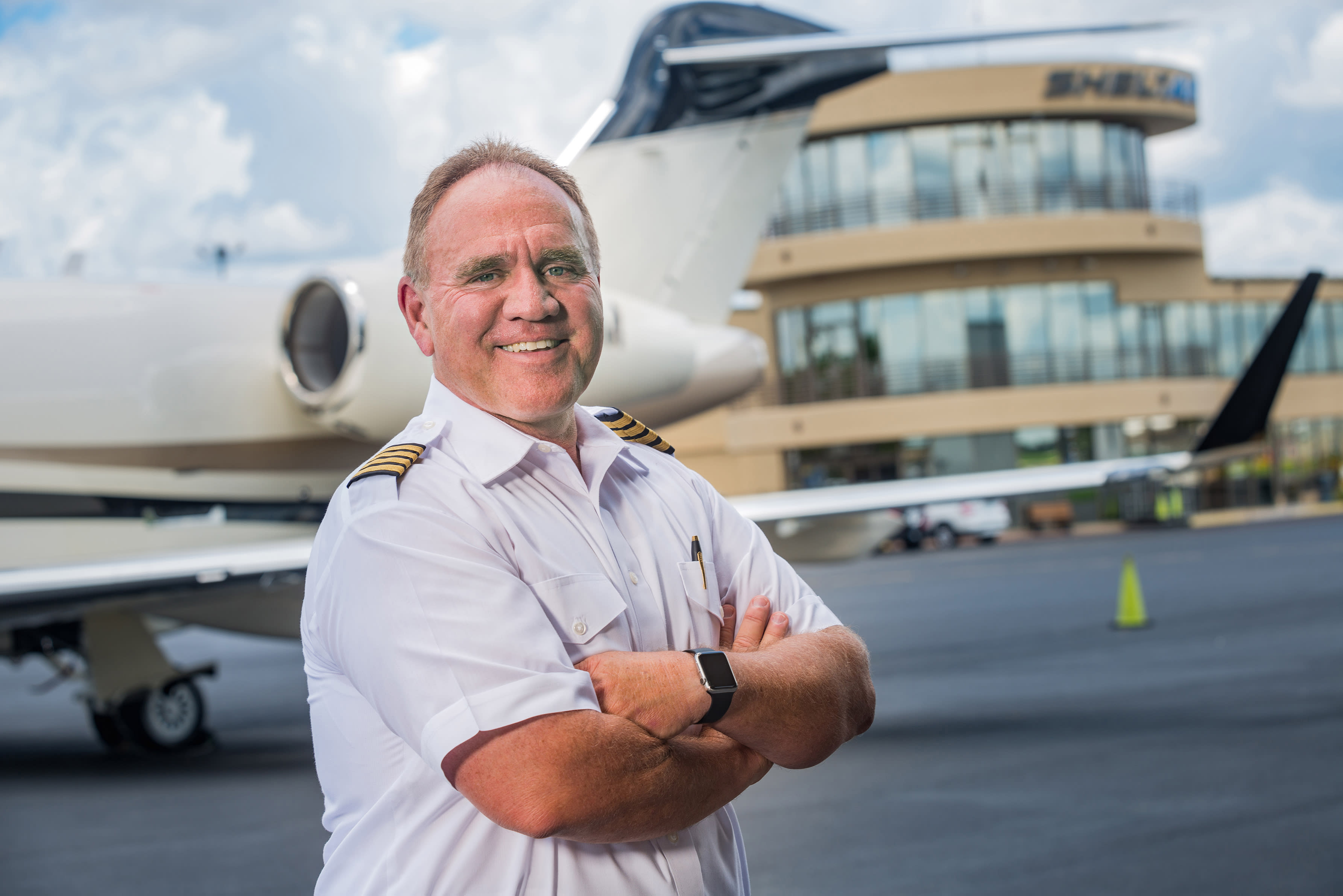 Pilot standing confidently in front of his plane.