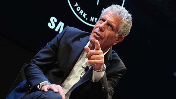 Anthony Bourdain sits onstage at an event.