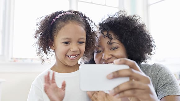 A child and adult looking at a phone screen