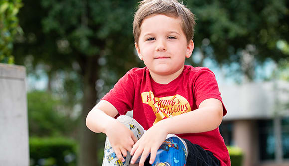 Gunnar sits on steps and smiles.