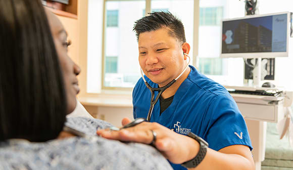 Baptist Health nurse listening to a female patient's heart