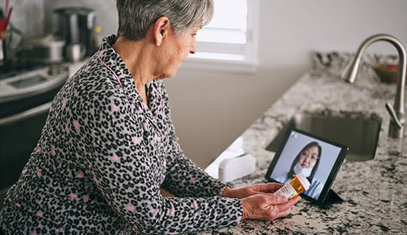 Older woman using Ipad to talk to her doctor online